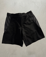 Black Champion training shorts laid flat, back view.